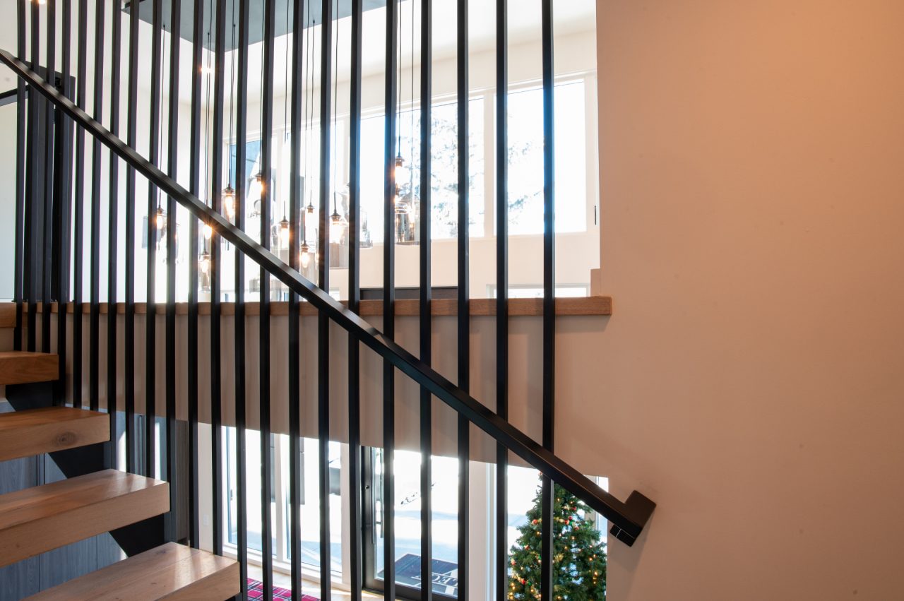 Modern staircase with hanging lights and Christmas tree